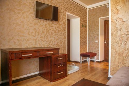 a living room with a television on the wall at Central Hotel Radviliškis in Radviliškis