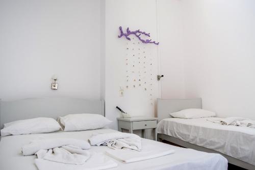 two beds in a room with white walls at Margo Antiparos in Antiparos