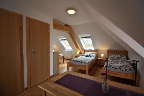 Zimmer im Dachgeschoss mit 2 Betten und einem Tisch in der Unterkunft U Slunce in Čížov