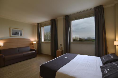 Un pat sau paturi într-o cameră la Tulip Inn Turin West Rivoli