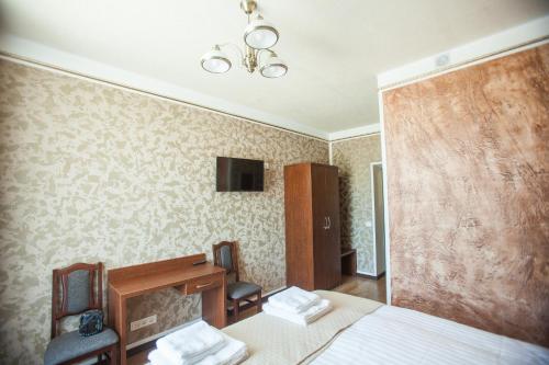 a hotel room with a bed and a desk and a chair at Central Hotel Radviliškis in Radviliškis