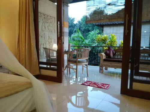 - une chambre avec un lit, une table et un balcon dans l'établissement Qiul Guest House, à Ubud