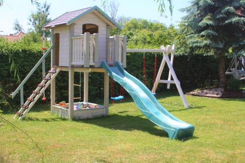 a playground with a slide and a play house at Pokoje, apartament NA WYSPIE in Gdańsk
