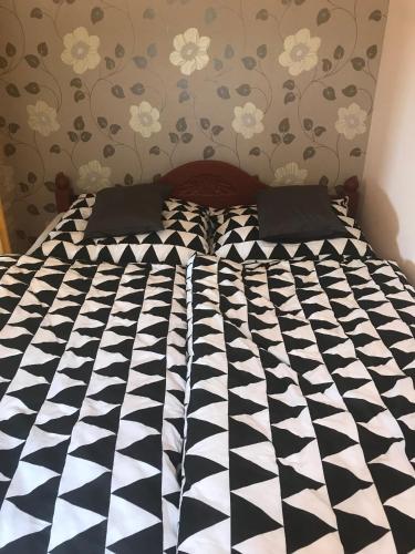 a black and white comforter on a bed at Kenese Panoráma Apartman in Balatonkenese