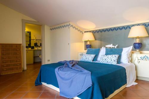 1 dormitorio con 1 cama grande de color azul y blanco en Les Suites - Apartments, en Riposto