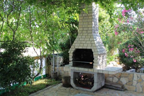 a stone oven in a yard with a garden at Apartments Novoselic in Vir