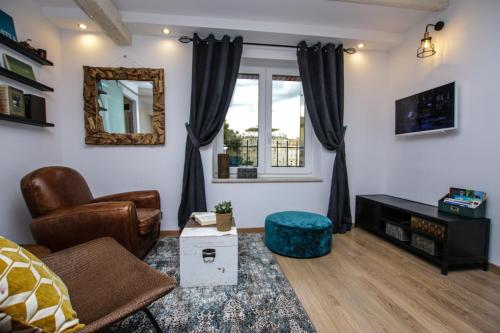 a living room with a couch and a window at Apartman Kika in Poreč