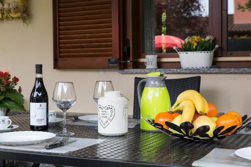 a table with a bowl of fruit and a bottle of juice at Casa Allegra in Orta San Giulio