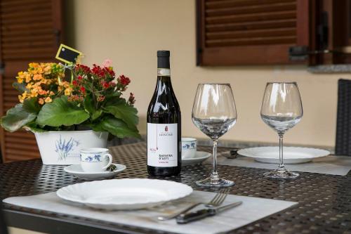 a bottle of wine sitting on a table with two glasses at Casa Allegra in Orta San Giulio