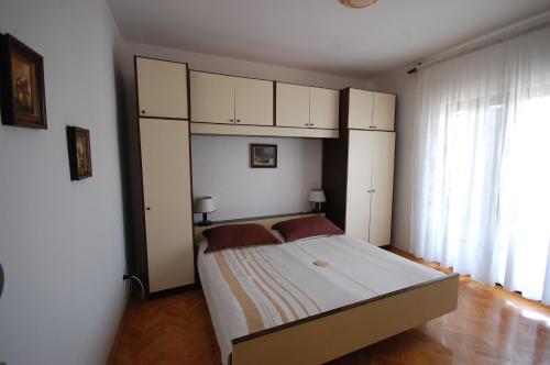 a bedroom with a large bed with white cabinets at Apartment Alex in Njivice