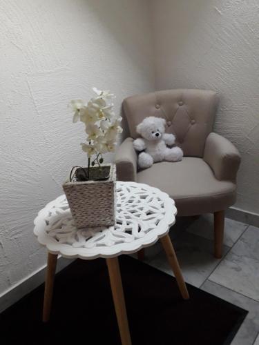 a teddy bear sitting in a chair with a table at Ferienwohnung Gogelhopf in Unterschneidheim