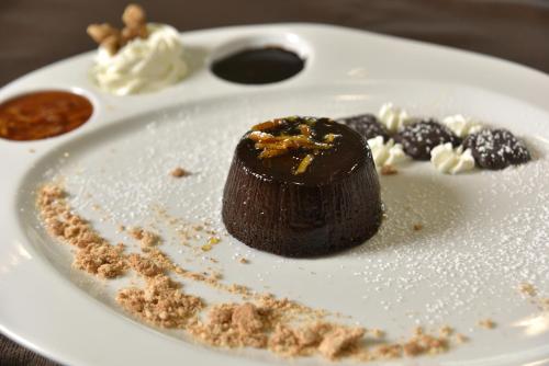 a chocolate dessert on a white plate on a table at Tulip Inn Turin West Rivoli in Rivoli