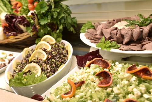 a buffet filled with plates of food on a table at Tulip Inn Turin West Rivoli in Rivoli