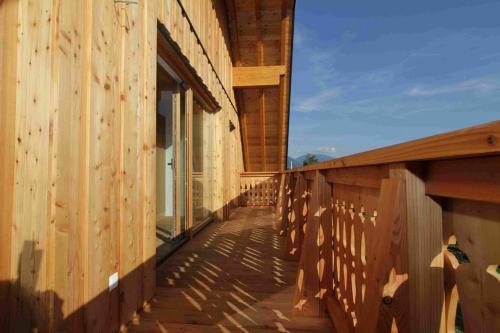 a wooden building with a walkway on the side of it at Landhaus Löscher in Seeboden