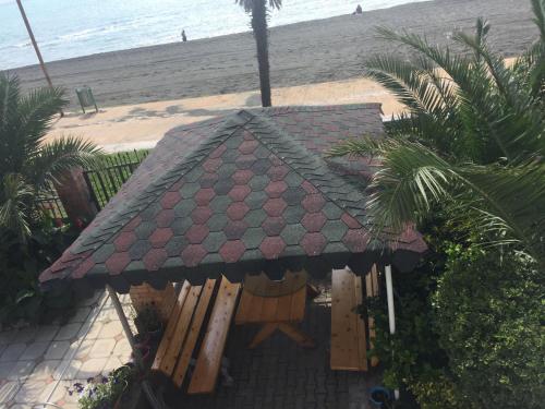 a gazebo on the beach next to the beach at Hotel George in Ureki