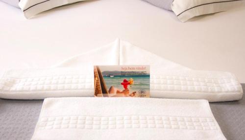a book sitting on top of a bed at Pousada Larimor in Boicucanga