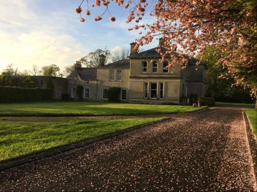 an old house with a driveway in front of it at Gardenvale Manor House B&B in Stranocum
