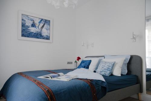 ワルシャワにあるASKI New Powiśle Copernicus Apartmentのベッドルーム1室(青いシーツと枕のベッド1台付)