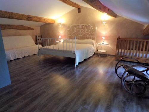 a bedroom with two beds in a room with wooden floors at Gîte " Suzon" à PEYROUTAS Vignonet St Emilion in Vignonet