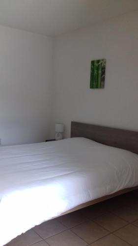 a white bed in a white room with at Résid'Artel Cadarache - ITER in Saint-Paul-lez-Durance