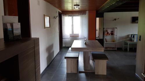 a kitchen with a wooden table and two benches at "Sous les Barres" in Montfaucon