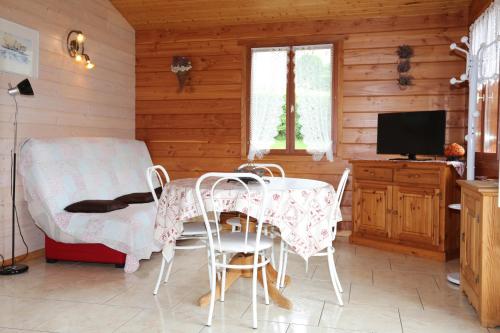 Un comedor con mesa y sillas y un televisor. en Chalet de Grettery, en Saulxures-sur-Moselotte