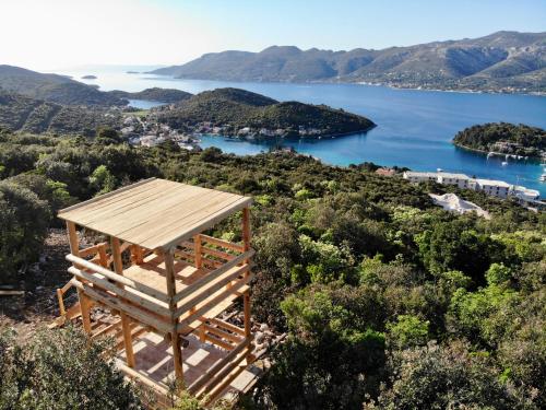 a wooden table on top of a hill overlooking a body of water at Korcula Hill in Korčula
