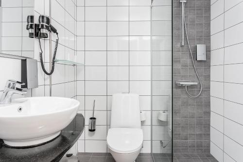 a bathroom with a sink and a toilet and a shower at Hotell Nova in Karlstad