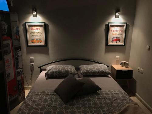 a bedroom with a bed and two posters on the wall at Q luxury rooms Perea center in Perea