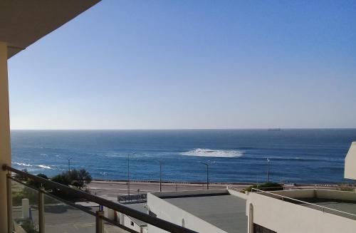 a view of the ocean from the balcony of a building at Atlantic Beach-side Apartment in Figueira da Foz