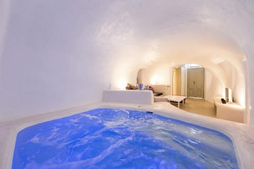 メガロホリにあるKampanario Luxury Villaのリビングルーム付きの客室で、大きな青いバスタブが備わります。