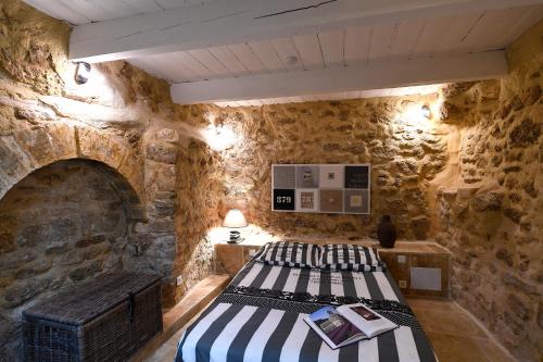 メネルブにあるLe petit trésor du Luberonの石壁のベッドルーム1室