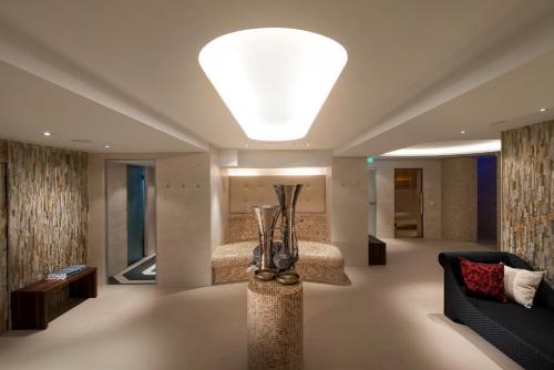 a living room with a couch and a large light fixture at Steigenberger Icon Frankfurter Hof in Frankfurt/Main