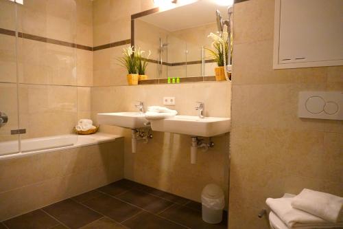un bagno con due lavandini e uno specchio di Alpin & See Resort a Zell am See
