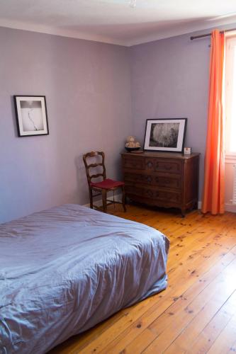 ル・ピュイ・アン・ヴレにあるAppartement centre ville Le Puyのベッドルーム1室(ベッド1台、椅子、ドレッサー付)