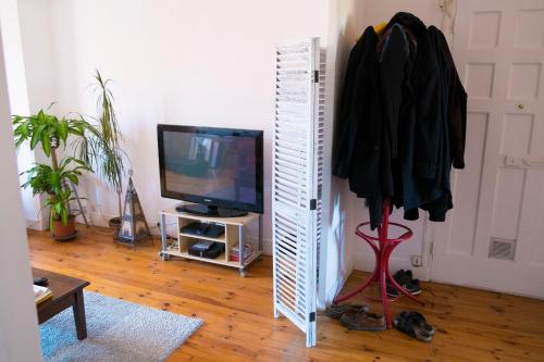 a living room with a television and a room with a door at Appartement centre ville Le Puy in Le Puy en Velay
