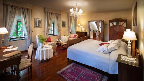 a bedroom with a large bed and a living room at Kendov Dvorec in Spodnja Idrija