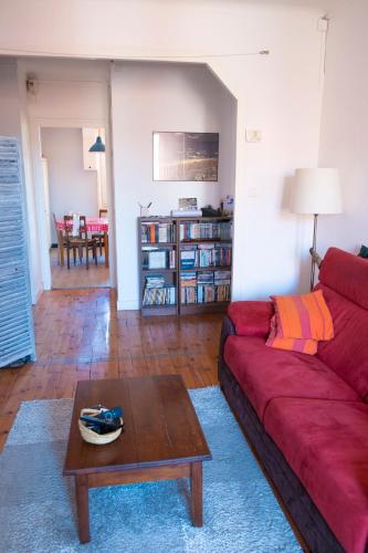 a living room with a red couch and a table at Appartement centre ville Le Puy in Le Puy en Velay
