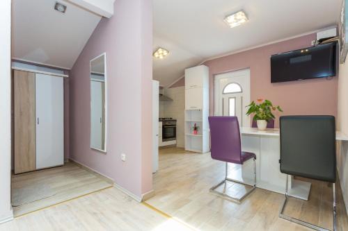 a living room with a table and purple chairs at New apartment with terrace and sea view in Lopud Island
