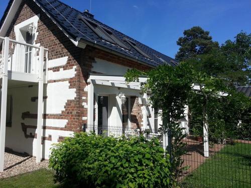 a brick house with a white fence in front of it at Scheunenhaus Kienspan in Tornitz