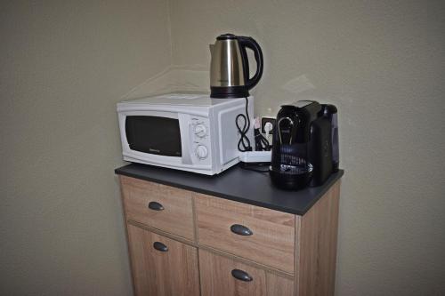 a microwave sitting on top of a cabinet with a coffee maker at GuestHouse Belo Horizonte in Porto