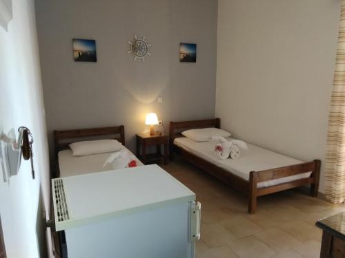 a room with two beds and a table with a lamp at Rooms Leonidas in Kissamos