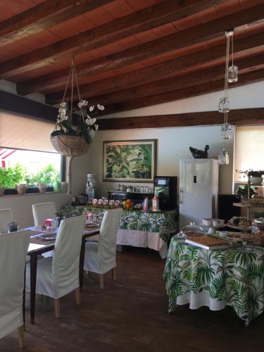 una sala da pranzo con tavoli e sedie bianche di B&B Il Portico a Sarzana