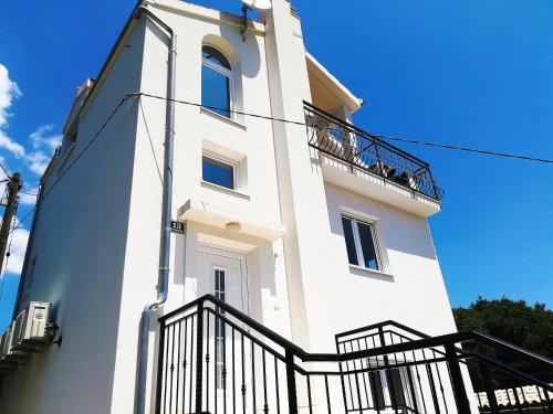 a tall white building with a black balcony at Holiday Home Lydia in Slatine
