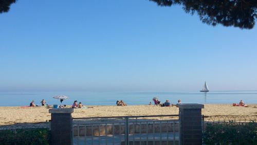 a group of people on a beach with a sail boat at Playa Esquirol in Cambrils
