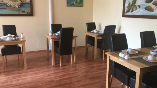 a room with four tables and chairs with plates on them at StadtHotel Bad Fallingbostel in Bad Fallingbostel