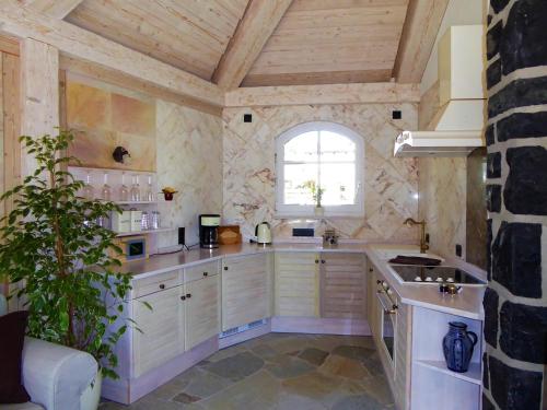 a large kitchen with white cabinets and a window at Ferienhaus Waldernbach in Mengerskirchen