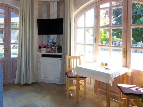uma sala de jantar com uma mesa e uma televisão na parede em Ferienhaus Waldernbach em Mengerskirchen