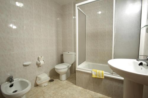 a bathroom with a toilet and a sink and a shower at Hostal San Roque in Portonovo