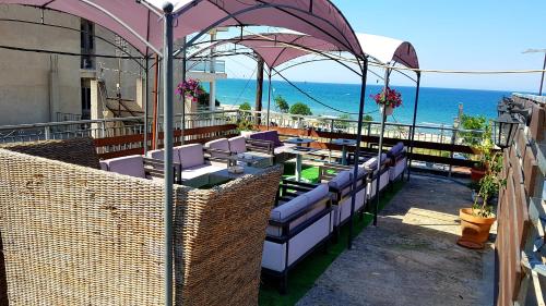 d'un balcon avec des chaises et des tables donnant sur l'océan. dans l'établissement Seaside Apartments & Rooms Kampouri, à Stomio
